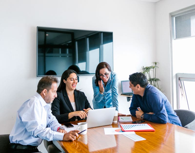 Business team meeting around a laptop in a conference room